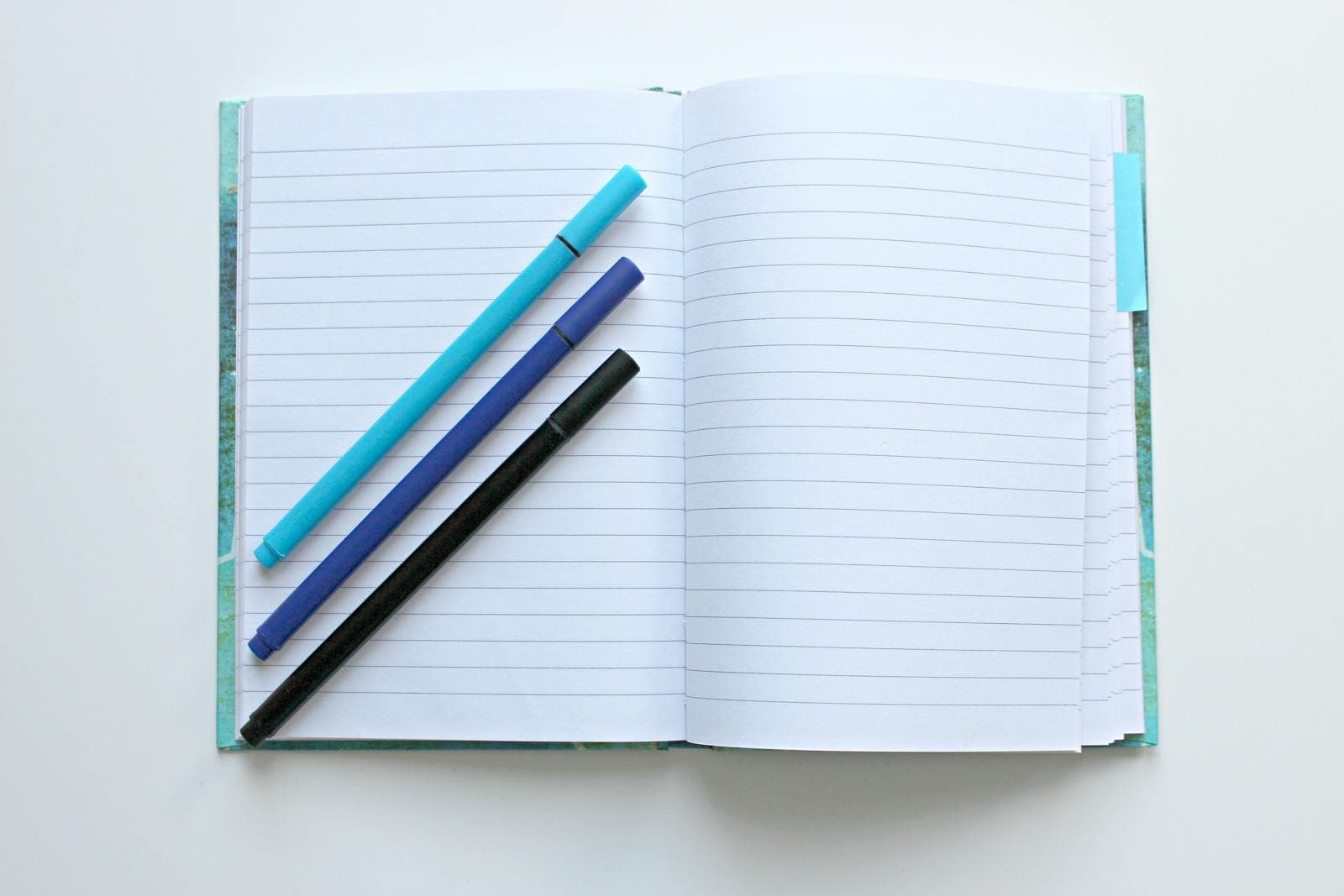 A laptop, notebook, and printed charts laid out for SEO keyword planning